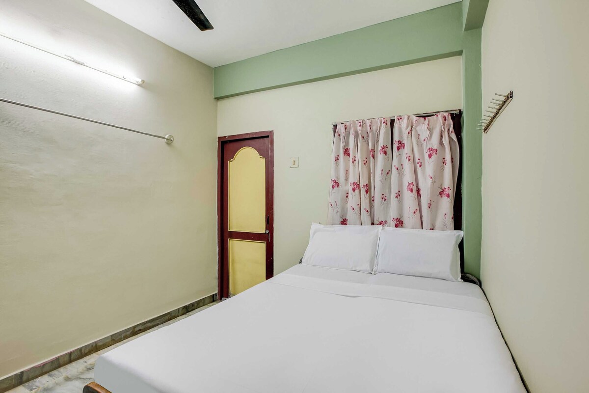 Un dormitorio con una cama, una puerta y una cortina.