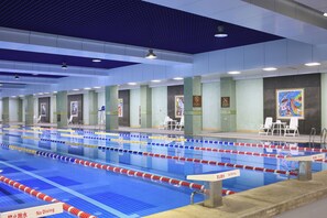 Una piscina con múltiples carriles, delimitados por separadores rojos y blancos, y un cartel que indica 'No Diving'.