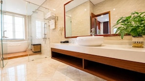 A modern bathroom with a large mirror, a white sink, and a shower area. - Grand Hotel (Hòa Bình)