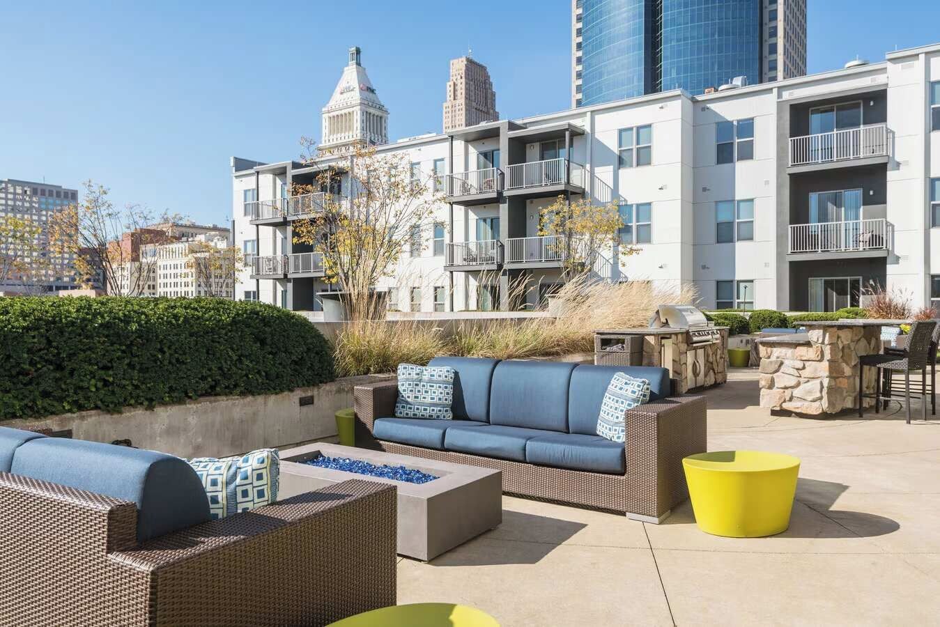 An outdoor patio area with seating, a fire pit, and a grill.