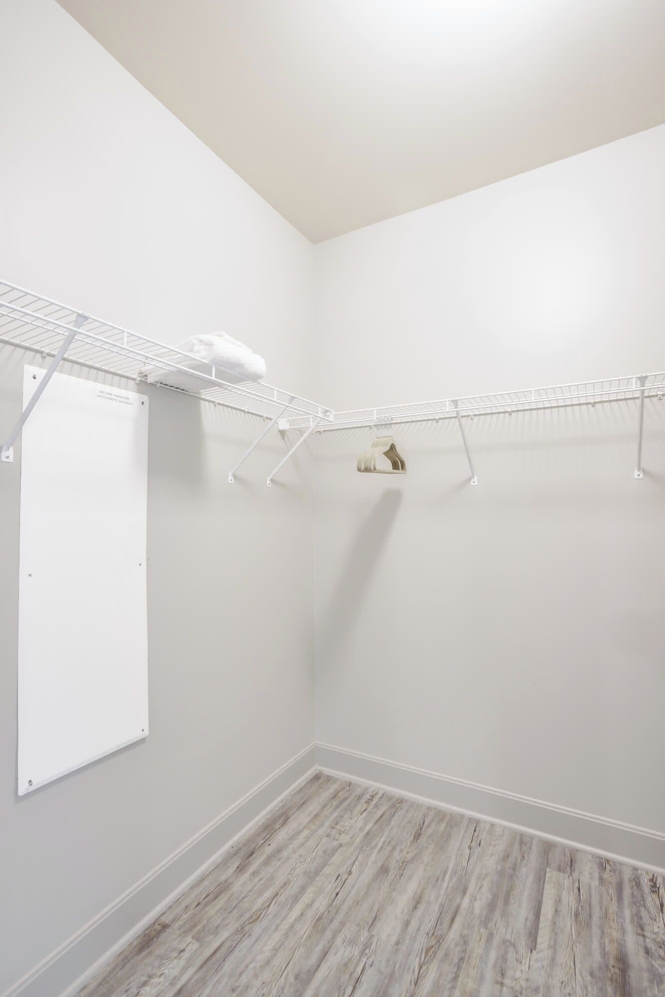 Une buanderie avec un mur blanc, un plancher en bois et un plafond blanc.