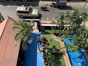 A rooftop pool area with seating and palm trees. - White Castle (Siem Reap)