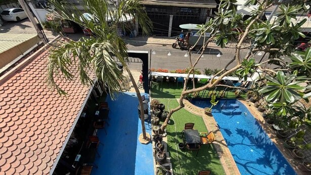 A rooftop pool area with a blue pool, outdoor seating, and potted plants. - White Castle (Krong Siem Reap)