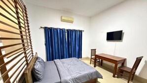 A bedroom with a bed, a desk, a chair, a TV, and a window with curtains. - White Castle (Krong Siem Reap)