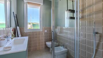 Ein Badezimmer mit Duschkabine, Toilette und Bidet.