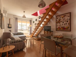 A modern living space with a staircase, a dining area, and a bedroom. - Mirador de San Felipe Neri (Málaga)