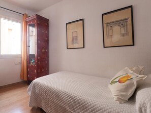 A bedroom with a bed, a wardrobe, and two framed pictures on the wall. - Mirador de San Felipe Neri (Málaga)