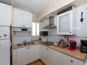 A compact kitchen with white cabinets, a microwave, a toaster, and a coffee maker. - Mirador de San Felipe Neri (Málaga)