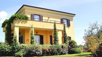 Un immeuble de deux étages doté d’un balcon et d’un jardin à l’avant.