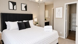 Une chambre à coucher avec un grand lit, un ventilateur de plafond et une table de chevet avec une lampe.