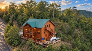 Eine mehrstöckige Blockhütte mit Balkon, Terrasse und Whirlpool.
