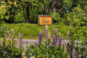 Placa com o nome 'The Villas' em um jardim exuberante.