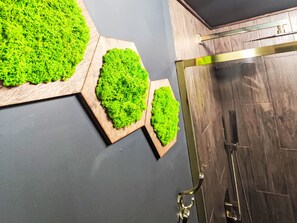 Ein Badezimmer mit Holzboden, einer Duschkabine und einem hängenden Handtuchhalter.