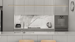 A modern kitchen with a marble backsplash, a built-in oven, and a coffee maker. - State Circle Stay | 10-Min Walk to Parliament (Forrest)