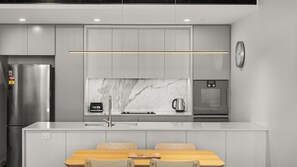A modern kitchen with a built-in oven, a coffee maker, and a refrigerator. - State Circle Stay | 10-Min Walk to Parliament (Forrest)
