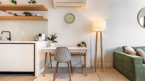 A modern kitchen with a white countertop, a built-in sink, and a wall-mounted air conditioner. - Eighteen Above Docklands Skyline & Pool (Docklands)