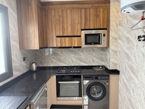 Una cocina compacta con microondas, horno y lavadora integrados.