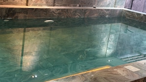 Ein klares Schwimmbecken mit Marmorrand und modernem Design.