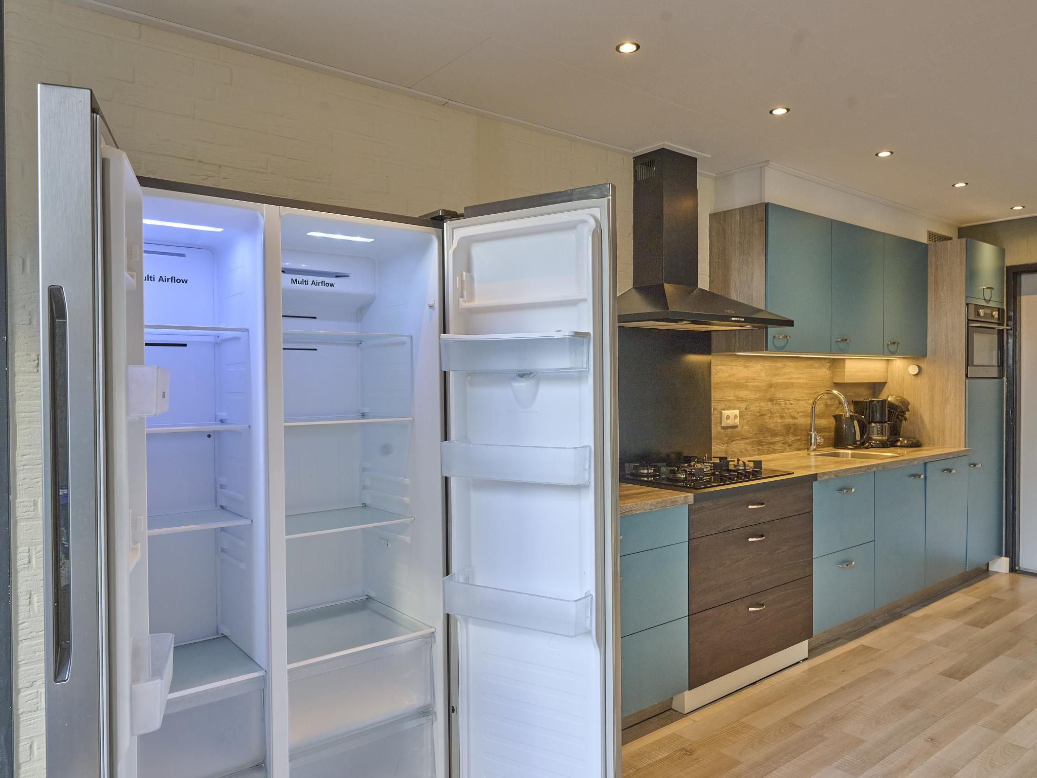 A modern kitchen with a built-in refrigerator, a stove, and a range hood.