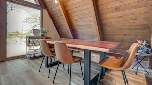 A dining area with a wooden table, four chairs, and a hanging light fixture. - LUXE | SKI-IN/OUT | Hot Tub | Fire Pit | A Frame (Beech Mountain)