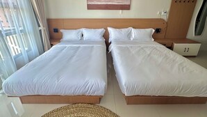 Une chambre d’hôtel avec deux lits, un tableau au mur et un appareil de climatisation.