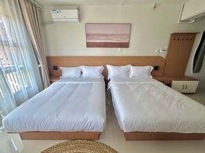 Quarto de hotel com duas camas, um quadro na parede e um aparelho de ar condicionado.