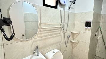 Un baño moderno con inodoro, lavamanos y ducha.