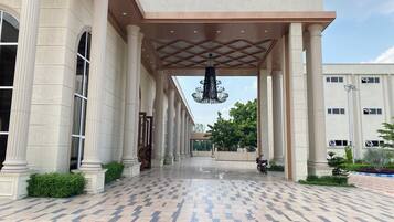 A building entrance with columns, a patterned floor, and a hanging chandelier.