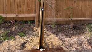 Une clôture en bois avec un poteau vertical et un tuyau de déversement.