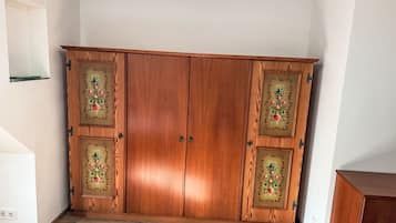 A wooden wardrobe with decorative glass panels and two handles.