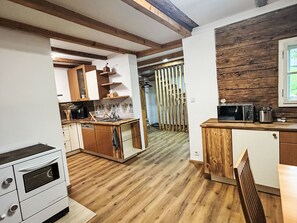 Eine moderne Küche mit Holzboden, integrierten Geräten und einer Wand in Holzoptik.