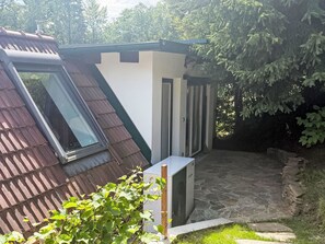 Un edificio residencial con techo inclinado, una ventana y una puerta.