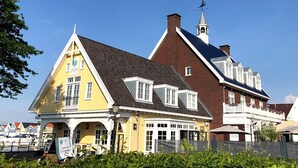 En gul bygning i traditionel arkitekturstil, med et markant tårn og vejrhane.