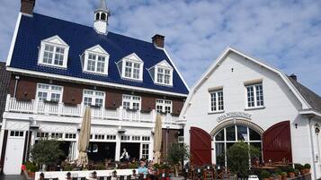 A traditional European building with a blue tiled roof and a white facade.