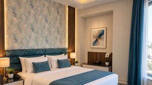 A modern hotel room with a large bed, a nightstand, a bedside table, a lamp, a potted plant, and a window with curtains. - Bangui (Amman)