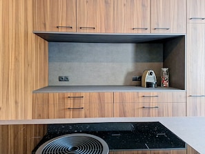 A modern kitchen with wooden cabinets, a built-in stove, and a small countertop area. - "das maridl" by Interhome (Ried im Oberinntal)