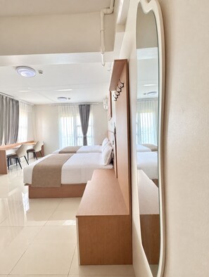 Una habitación de hotel moderna con una cama grande, un escritorio y un espejo.