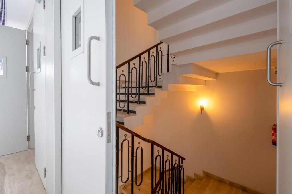 Una escalera con barandilla e iluminación empotrada en la pared.