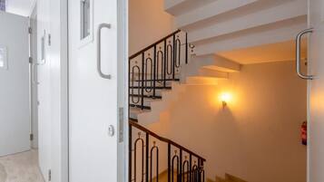 Una escalera con barandilla e iluminación empotrada en la pared.