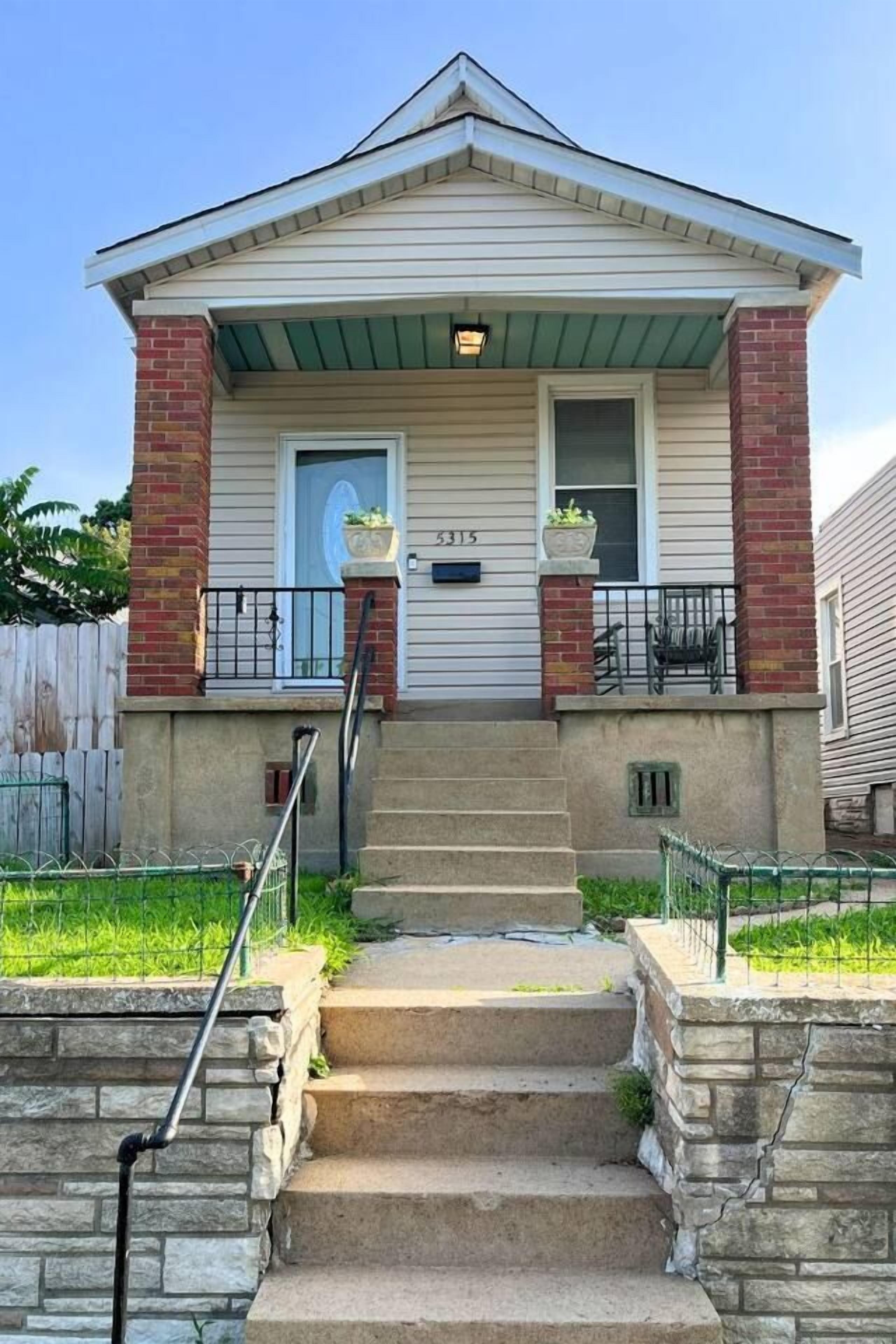 A two-story house with a front porch, a brick chimney, and a number '5315' on the door.