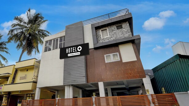 A modern hotel building with a sign indicating it is company-serviced. - Hotel Central Vishwanathapuram Formerly (Coimbatore)