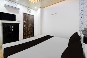 A hotel room with a bed, a wardrobe, a television, and a wall-mounted air conditioning unit. - OYO Ambedkar Gorakhpur Residency (Lucknow)