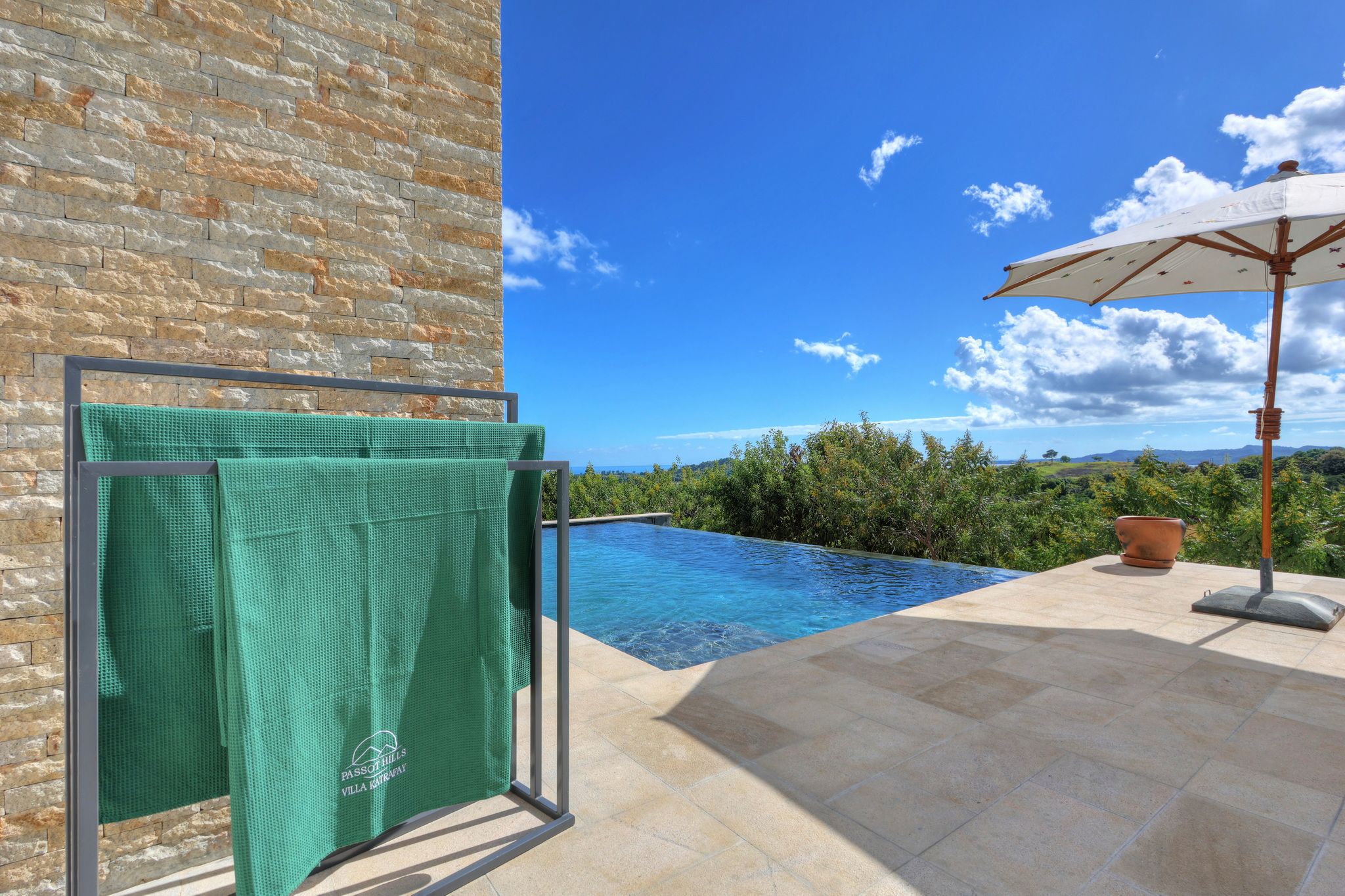 Una piscina con cielo azul despejado y montañas al fondo.