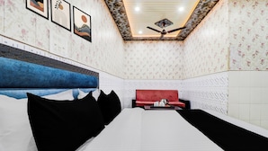 Een hotelkamer met een bed, een rode bank en een plafondventilator.