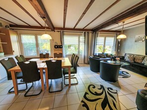 Un coin repas avec une table et des chaises en bois, un canapé et un tapis à motifs.