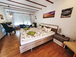 Une chambre à coucher avec un lit en bois, un bureau et une chaise.
