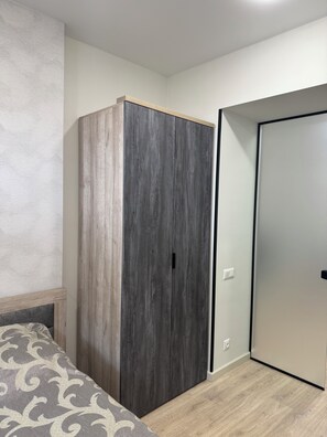Une chambre à coucher avec un lit, une armoire et une porte.