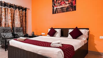 Quarto de hotel com uma cama grande, uma mesa e uma cadeira.