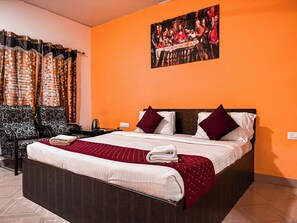 Una habitación de hotel con una cama grande, un escritorio y una silla.
