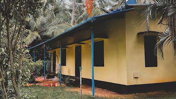 A single-story building with a flat roof, surrounded by dense tropical vegetation.